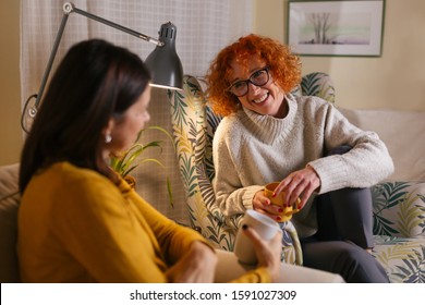 Middle Aged Female Friends Having Fun At Home, Drinking Coffee And Talking
