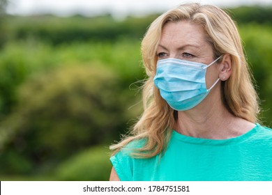 Middle Aged Female Woman Wearing Face Mask Outside In The Coronavirus COVID-19 Pandemic