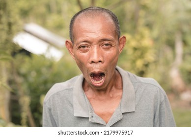 A Middle Aged Filipino Male Gasps In Astonishment And Disbelief. A Simple Person In Stunned Bewilderment. Outdoor Scene.