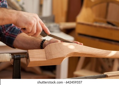 Middle aged handsome carpenter  making final touches to the Cabrioli table (or chair leg)/Carpenter Making Cabrioli Table (or Chair) Legs - Powered by Shutterstock