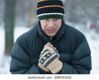 Middle aged handsome man in the cold winter day sitting on the bench in the Moscow public park VDNkH. Concept of leisure time and cold weather during winter season. Portrait, frontal view. Close up