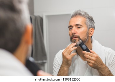 Middle Aged Handsome Man Trimming His Beard In Bathroom