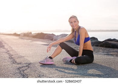 Middle Aged Healthy Woman Relaxing And Happy After Her Fitness Exercise. She Is Smiling And Looking At The Camera With Sunset In The Background. Gold Coast Australia. 