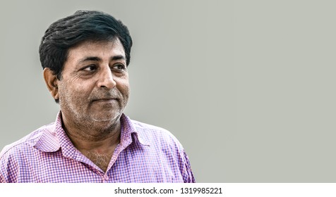 Middle Aged Indian Male Wearing Check Shirt, He Is A Typical Common Man Of India, Belonging To A Prosperous Middle Class Family. He Is Smiling And Is Satisfied With His Achievements And Expectations