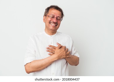 Middle aged indian man isolated on white background laughing keeping hands on heart, concept of happiness.