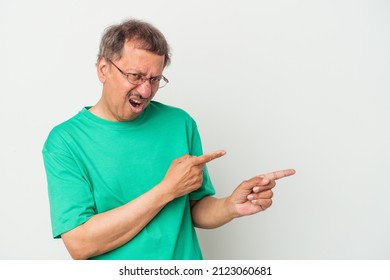 Middle aged indian man isolated on white background pointing with forefingers to a copy space, expressing excitement and desire.