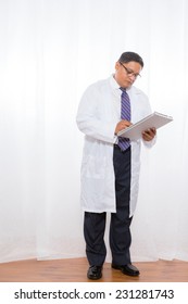 Middle Aged Latino Male Wearing A Lab Coat And Holding Clipboard