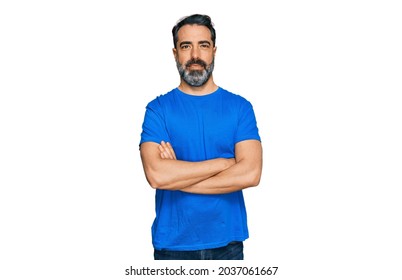 Middle aged man with beard wearing casual blue t shirt happy face smiling with crossed arms looking at the camera. positive person. 