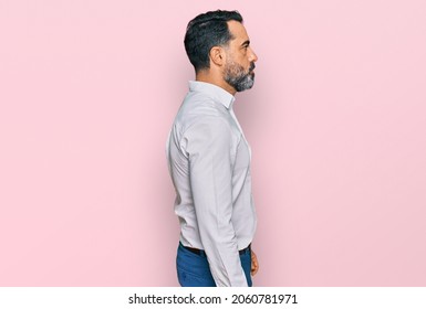 Middle Aged Man With Beard Wearing Casual White Shirt Looking To Side, Relax Profile Pose With Natural Face With Confident Smile. 