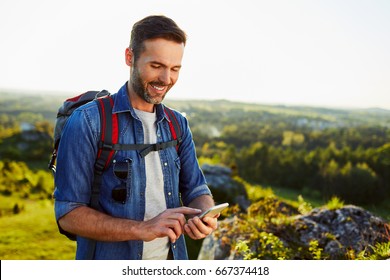 Middle Aged Man Checking Map On Phone While Hiking