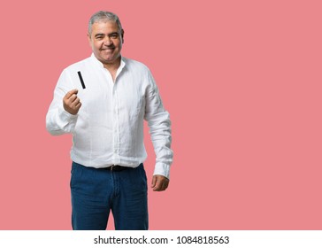 Middle Aged Man Cheerful And Smiling, Very Excited Holding The New Bank Card, Ready To Go Shopping