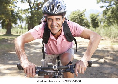 Middle Aged Man Cycling Through Countryside