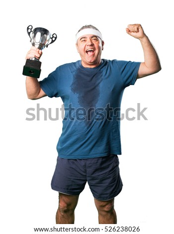 middle aged man doing winner gesture holding a trophy