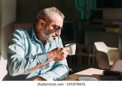 Middle aged man drinking first morning coffee on his job break in a cafe. Business people
