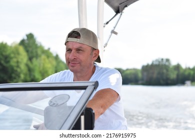 Middle Aged Man Driving Boat On A Lake