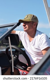 Middle Aged Man Driving Boat On A Lake