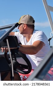 Middle Aged Man Driving Boat On A Lake