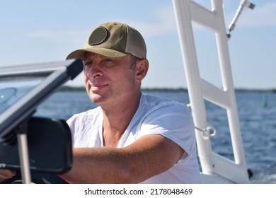 Middle Aged Man Driving Boat On A Lake