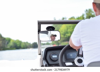 Middle Aged Man Driving Boat On A Lake