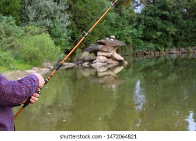 Middle Aged Man Fishing At Sunset On A Serene Country Pond In The Summertime