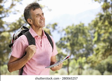 Middle Aged Man Hiking Through Countryside