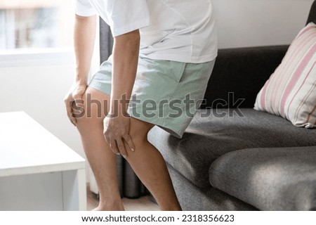 Middle aged man holding knees,pain in kneecap or muscles around knee joint,patella friction against the thigh bone,standing up with difficulty,disease of Runner's knee or Patellofemoral pain syndrome Stock foto © 