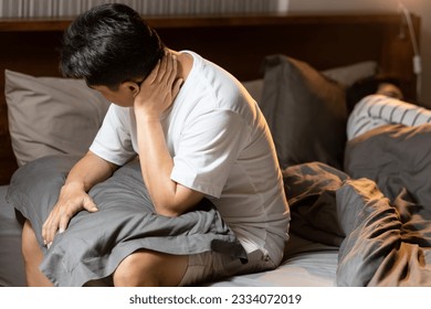 Middle aged man holding pillow,discomfort and pain in neck,shoulder,muscle strain or sprain,neck stiffness,difficulty moving the neck,problem of bad pillow or poor posture,wrong sleeping positions