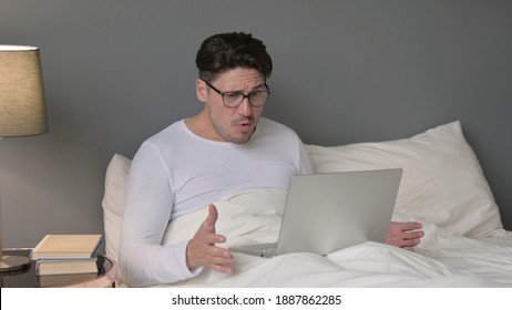 Middle Aged Man with Laptop having Loss in Bed - Powered by Shutterstock