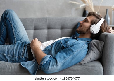 Middle aged man listening music with headphones relaxed in sofa at his home. - Powered by Shutterstock