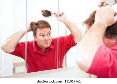 Middle Aged Man Looking For Bald Spots In The Mirror.