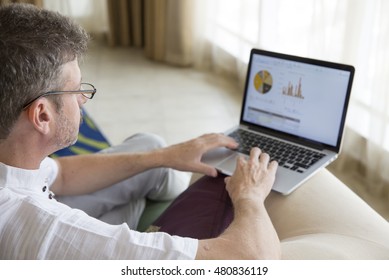 Middle Aged Man Looking At His Finances In His Computer