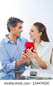Middle aged man making proposal of marriage to beautiful woman while sitting at table