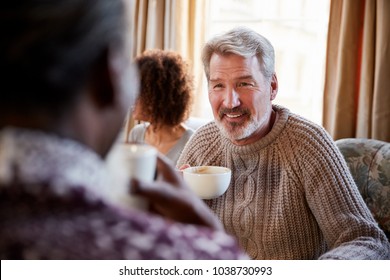 Middle Aged Man Meeting Friends Around Table In Coffee Shop