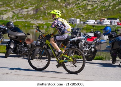 Middle Aged Man On Mountain Bike At Summit Of Gotthard Pass On A Sunny Summer Day. Photo Taken June 25th, 2022, Gotthard Pass, Switzerland.