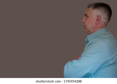 Middle Aged Man Portrait With Crossed Hand. Profile Side View On Isolated Background. 40 Years Man Not Looking At Camera. Blue Business Shirt Is Dressed. Thinking Face And Calm Emotions