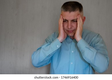 Middle Aged Man Portrait Touching His Head Temples With Hands. 40 Years Man Not Looking At Camera. Blue Business Shirt Is Dressed. Sad Face And Negative Emotions