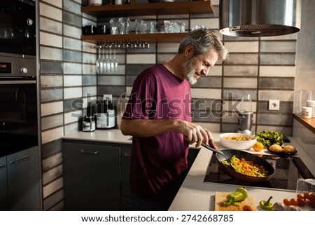 middle aged man preparing breakfast at home 