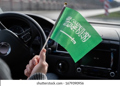 Middle Aged Man With Saudi Arabia Flag Driving A Car. 