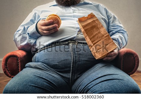 middle aged man snacking in an armchair