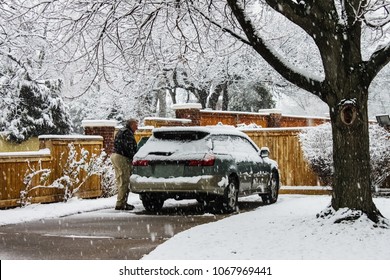 Middle Aged Man With Snow Covered Car In Driveway On Extremely Snowy Day With Snow Falling