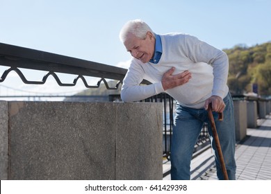 Middle aged man suffering from pain in the street