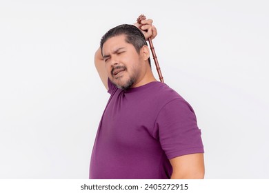 A middle aged man using a backscratcher to scratch and relieve an itch on his upper back. Looking satisfied. Isolated on a white background.
