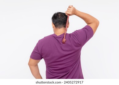 A middle aged man using a backscratcher to scracth and relieve an itch on his upper back. Rear view, isolated on a white background.