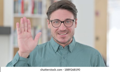 Middle Aged Man Waving At The Camera 