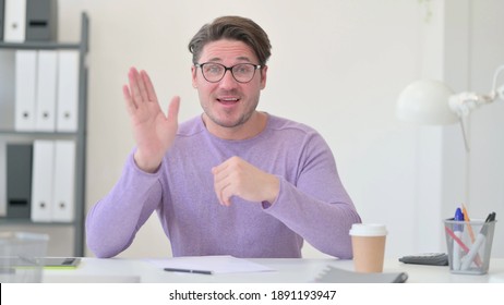 Middle Aged Man Waving Hand For Talking On Video Call