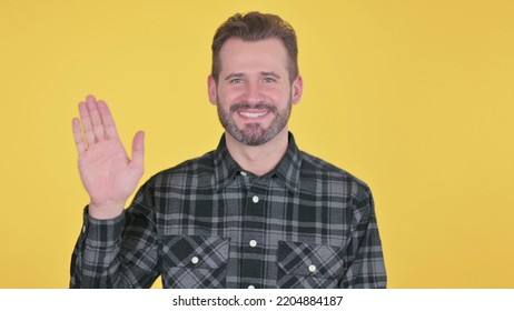 Middle Aged Man Waving To Welcome, Yellow Background