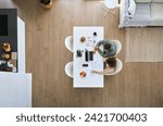 Middle aged man and woman using laptop computer sitting at table in living room interior. Mature couple calculating finance expenses, money savings, paying bills online at home. Top view from above.