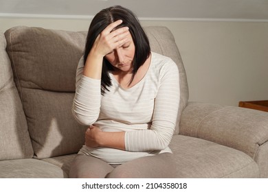  Middle Aged Mature Pregnant Woman Suffering From Headache And Stomach Ache, Toxicosis At Home. Abdominal Pain, Food Poisoning, Diarrhea, Stomach Ulcer, Menstruation Pain.                             