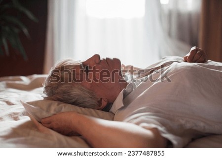 Middle aged mature woman insomniac lying awake in bed looking up trying to sleep, unhappy old senior lady feel disturbed frustrated suffer from insomnia concept uncomfortable bad mattress