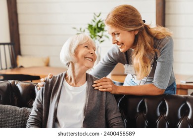 Middle aged nurse taking care of old woman indoors. Caregiver caretaker carer medical worker visiting grandmother senior patient with mental issues dementia in hospice - Powered by Shutterstock